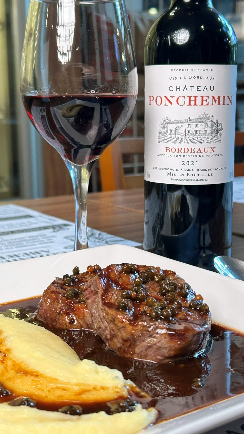 Medalhão de Filé Mignon ao molho poivre com aligot, servido com a garrafa do vinho tinto Château Ponchemin Bordeaux 2021